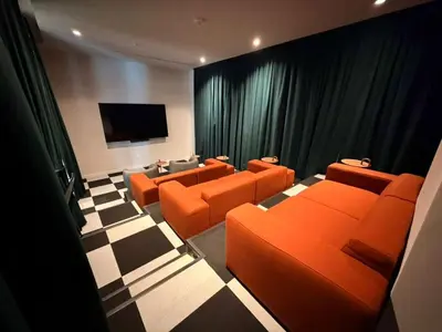 a waiting room with orange chairs and a flat screen tv at Lujoso apartamento ,The Crosby Miami World Center in Miami