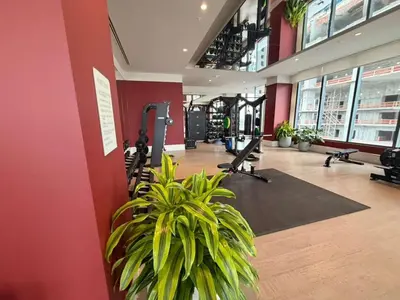 a gym with tread machines and a plant in a room at Lujoso apartamento ,The Crosby Miami World Center in Miami