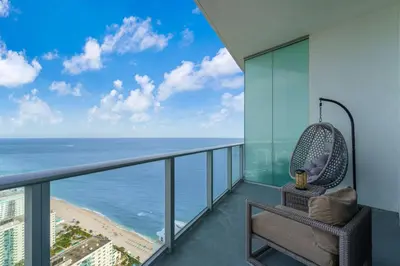 a balcony with a chair and a view of the ocean at Lyfe Resort Ocean View Gym Direct Beach Access in Hollywood