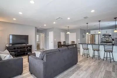 a living room with a couch and a kitchen at Private Luxe Pool Club Heated Spa in Fort Lauderdale