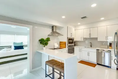 a kitchen with white cabinets and a large island at 3 Mi to Sea! Family Pool House in Fort Lauderdale in Fort Lauderdale