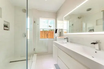 a white bathroom with a sink and a shower at 3 Mi to Sea! Family Pool House in Fort Lauderdale in Fort Lauderdale