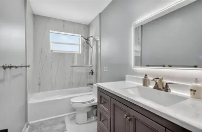 a bathroom with a sink and a toilet and a mirror at Spacious 3BR Home with Private Pool in Hollywood in Hollywood