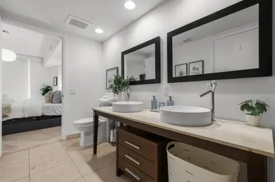 two sinks in a bathroom with a bedroom at The Palazzo, Heart of Miami, Rooftop Pool, Lux Spa in Miami