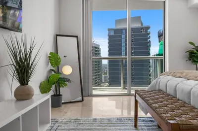 a bedroom with a large window with a view of a city at The Palazzo, Heart of Miami, Rooftop Pool, Lux Spa in Miami