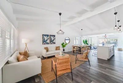 a living room with white furniture and a table at Waterfront Pool Home to Few Minutes to Beach in Fort Lauderdale