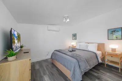 a bedroom with a bed and a flat screen tv at Waterfront Pool Home to Few Minutes to Beach in Fort Lauderdale