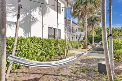 a hammock in front of a building at Walnut Beach - By Atlantikos in Hollywood