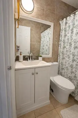 a bathroom with a sink and a toilet and a mirror at Cassa Wynwood in Miami
