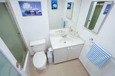 a white bathroom with a toilet and a sink at The Tides on Hollywood Beach in Hollywood