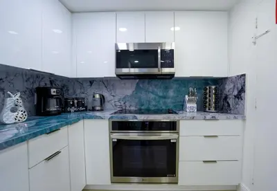 a kitchen with white cabinets and a microwave at The Tides on Hollywood Beach in Hollywood