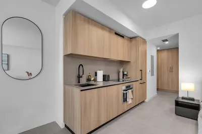 a kitchen with wooden cabinets and a sink at Brand New Modern Downtown Studio at Prime Location in Miami