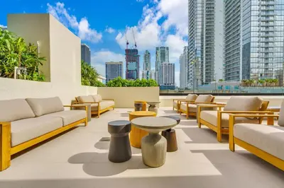 a rooftop patio with couches and tables and a city at Free Parking Downtown Condo with Resort Amenities in Miami