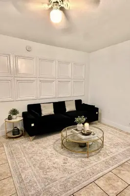 a living room with a black couch and a table at Best location in Coconut Grove in Miami