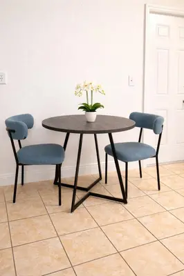 a table with two chairs and a vase with flowers at Best location in Coconut Grove in Miami