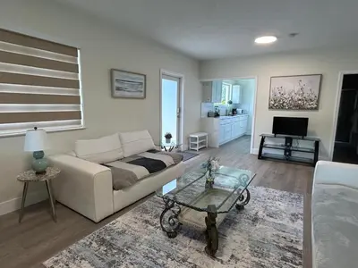 a living room with a white couch and a table at Spring Village by the Canal Loft in Miami
