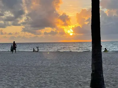 a group of people walking on the beach at sunset at Intracoastal Oasis in Fort Lauderdale