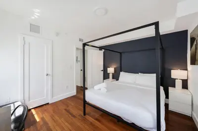 a bedroom with a large white bed with a black frame at Alton Apts By At Mine Hospitality in Miami Beach