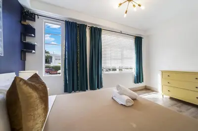 a bedroom with a bed and a large window at Drexel Apts By At Mine Hospitality in Miami Beach