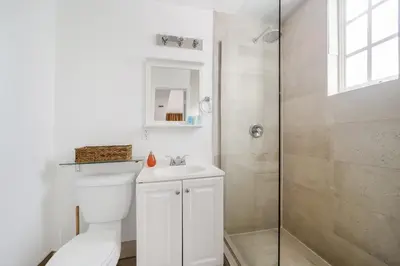 a white bathroom with a toilet and a shower at Drexel Apts By At Mine Hospitality in Miami Beach