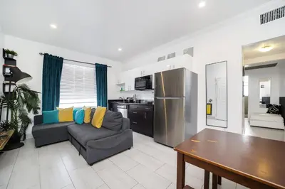 a living room with a couch and a kitchen at Drexel Apts By At Mine Hospitality in Miami Beach