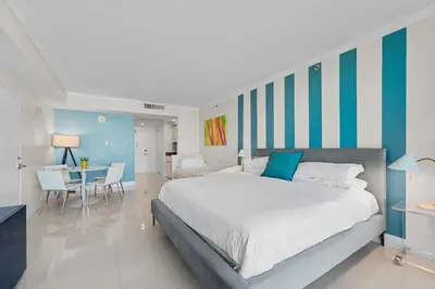 a bedroom with a large bed and a dining room at Arya Hotel & Suites in Miami