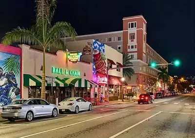 a city street at night with cars stopped at a traffic light at 78 Tropical soak in Miami