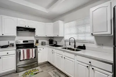 a kitchen with white cabinets and a sink and a stove at 397 A - Beautiful Home in Miami in Miami