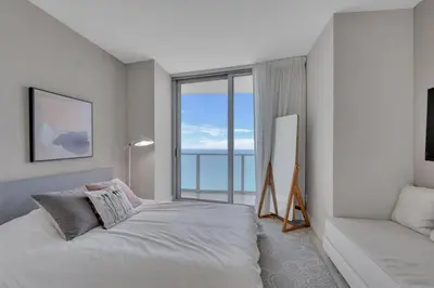 a bedroom with a bed and a large window at Prime Oceanfront 3BR Mansion in the Sky in Hollywood