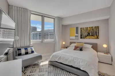a white bedroom with a bed and a window at Prime Oceanfront 3BR Mansion in the Sky in Hollywood