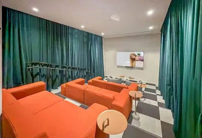 a living room with orange furniture and green curtains at Modern MIA Worldcenter Studio with Balcony Pool & Gym in Miami
