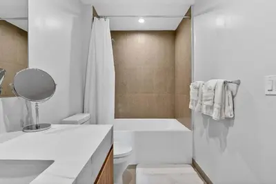a white bathroom with a toilet and a shower at The Crosby Miami Worldcenter Downtown Miami in Miami