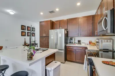 a kitchen with wooden cabinets and a refrigerator at Easy Park and University Access! Family Miami Escape in Miami