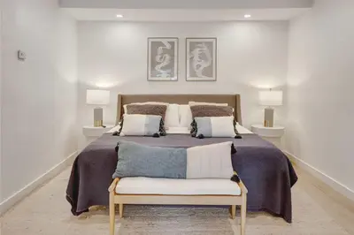 a bedroom with a large bed with two lamps at Casa in Tropic Paradise with Pool and BBQ in Biscayne Park