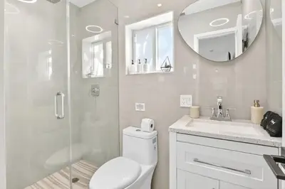 a bathroom with a toilet and a shower and a mirror at Spacious Miami 4BR Retreat with Pool & BBQ in Miami