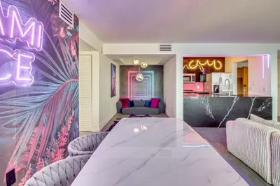 a dining room with a table and a kitchen at Luxe Miami Vice Condo! Bay Views and Pool Access in Miami