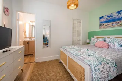 a bedroom with a bed and a flat screen tv at Tropical Retreat with Private Yard, Fire Pit, Hammock in Hollywood