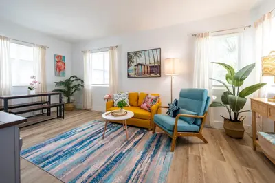 a living room with a yellow couch and a blue chair at Tropical Retreat with Private Yard, Fire Pit, Hammock in Hollywood