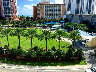 a park with palm trees in a city at Ocean Reserve Miami Luxury Rentals in Sunny Isles Beach
