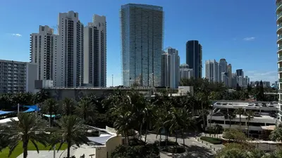 a city skyline with tall buildings and palm trees at Ocean Reserve Miami Luxury Rentals in Sunny Isles Beach