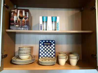 a shelf with plates and glasses and a wine glass at Ocean Reserve Miami Luxury Rentals in Sunny Isles Beach