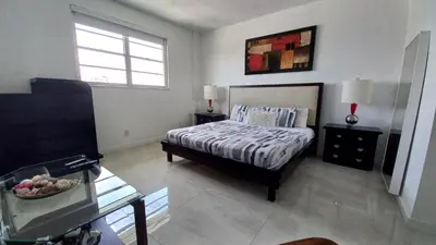 a bedroom with a bed and a table and a window at Penthouse Ocean Reserve in Miami Beach