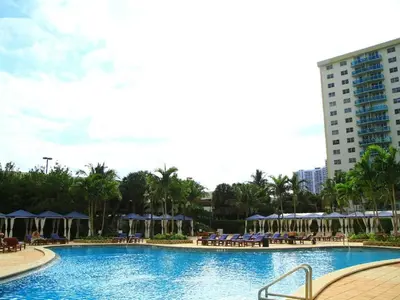 a pool with chairs and umbrellas in a resort at Penthouse Ocean Reserve in Miami Beach