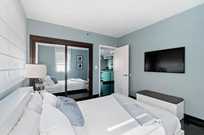 a bedroom with a white bed and a television at Casa Grande Suites on Ocean Drive in Miami Beach