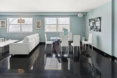 a dining room with a table and white chairs at Casa Grande Suites on Ocean Drive in Miami Beach