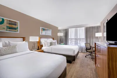 a hotel room with two beds and a flat screen tv at Holiday Inn Miami West - Airport Area by IHG in Hialeah Gardens