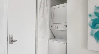 a bathroom with a washer and dryer next to a door at Beachwalk Resort Residence in Hollywood
