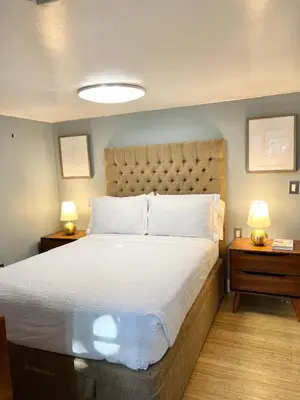 a bedroom with a large bed with two night stands at Harmonious Suites in North Miami Beach