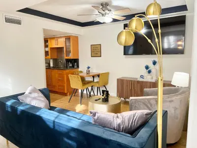 a living room with a blue couch and a table at Harmonious Suites in North Miami Beach