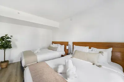 two beds in a room with white walls at The Meridian Hotel by At Mine Hospitality in Miami Beach